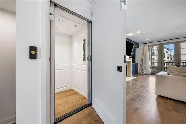a view of a hallway with wooden floor and cabinet