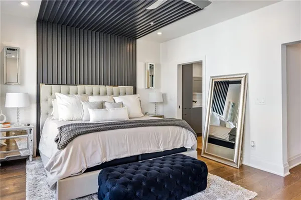 a bedroom with a bed lamp and a large window