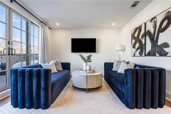 a living room with furniture a flat screen tv and a window