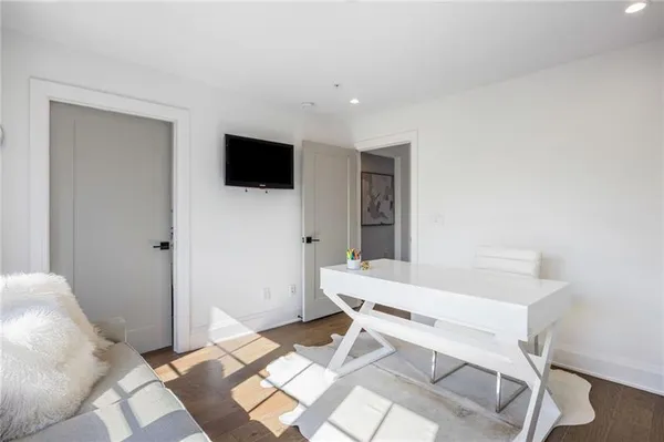 a living room with a bed furniture and a flat screen tv