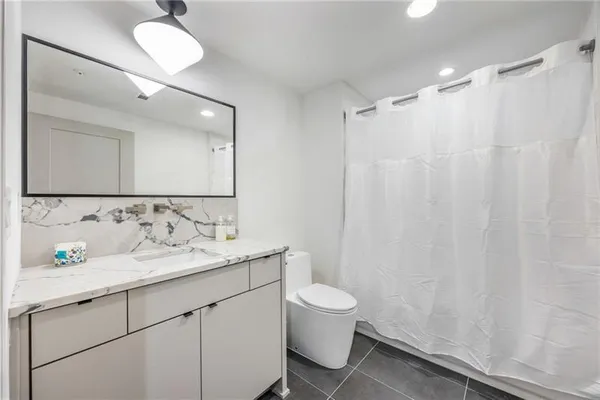 a bathroom with a sink a toilet and a mirror