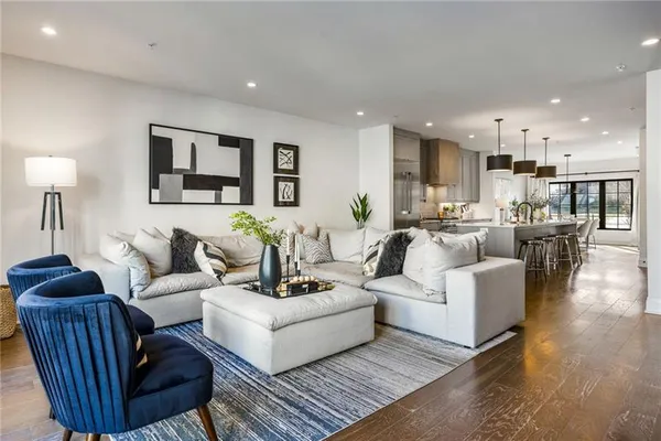 a living room with furniture and a view of kitchen