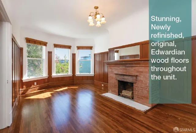 a living room with wooden floor and a fireplace