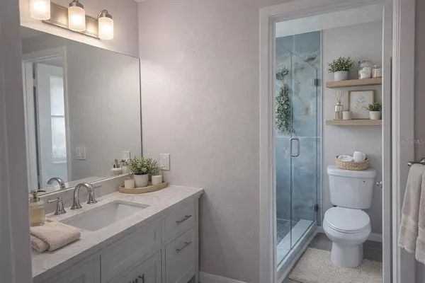 a bathroom with a toilet a sink and glass door