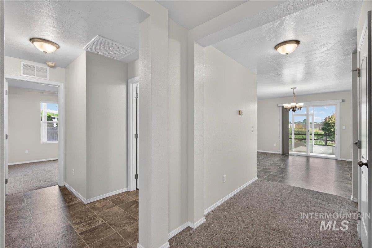 1555 Condor Drive Middleton, ID 83644 - Photo 16 of 50 Interior spaces featuring light-toned walls, mixed flooring of carpet and tile, and a sliding glass door leading to an outdoor patio area