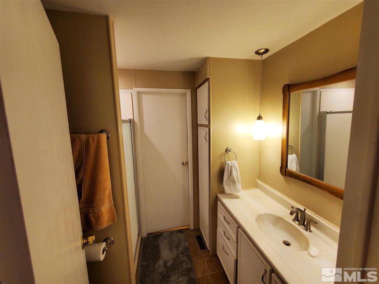 185 Aries Circle Reno, NV 89521 - Photo 17 of 18 a bathroom with a double vanity sink and a mirror