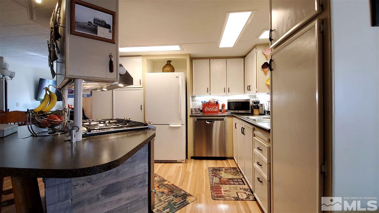 185 Aries Circle Reno, NV 89521 - Photo 5 of 18 a kitchen with sink a refrigerator and chairs