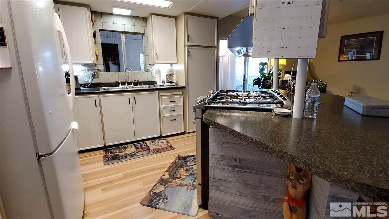 185 Aries Circle Reno, NV 89521 - Photo 6 of 18 a kitchen with stainless steel appliances granite countertop a sink stove and refrigerator
