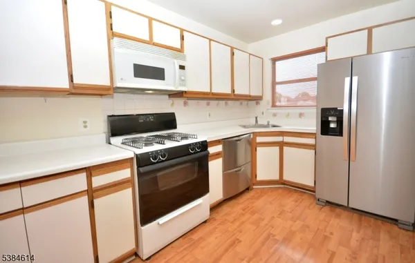 a kitchen with stainless steel appliances a stove and white cabinets