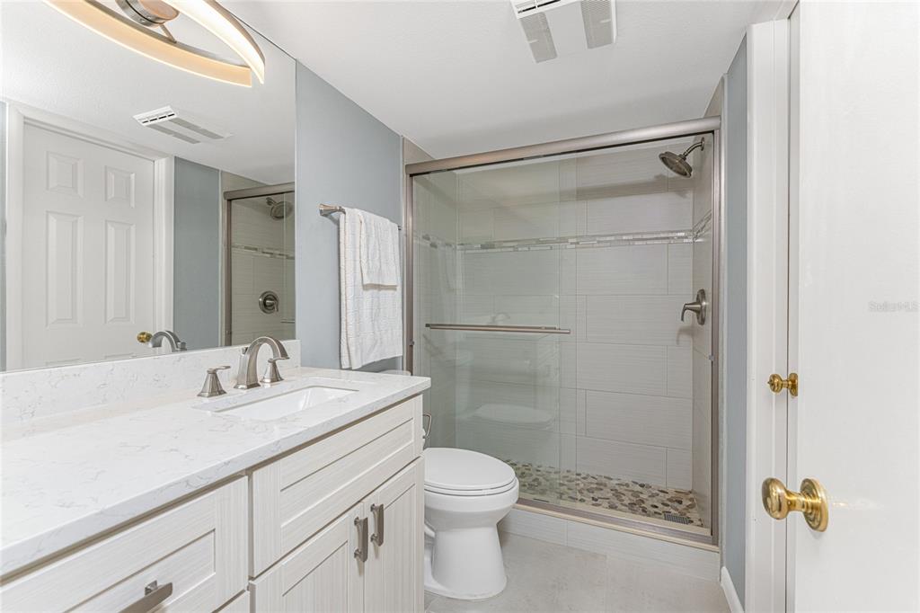 1401 Beach Road, Unit 303 Englewood, FL 34223 - Photo 32 of 63 a bathroom with a sink a toilet and shower