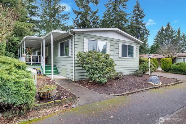 a front view of a house with a yard and potted plants