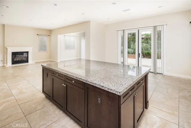 an empty room with windows and fireplace