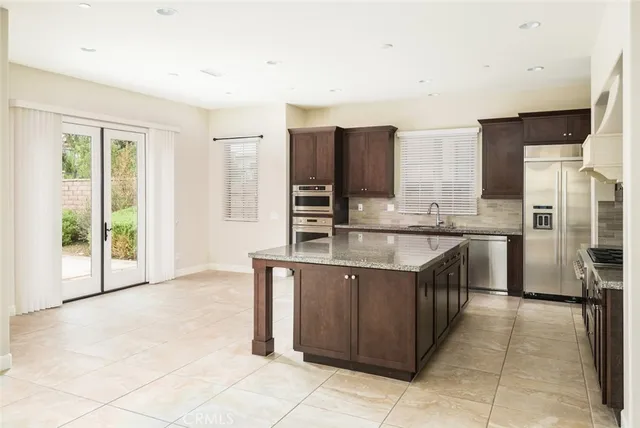 a kitchen with granite countertop a sink stove and refrigerator