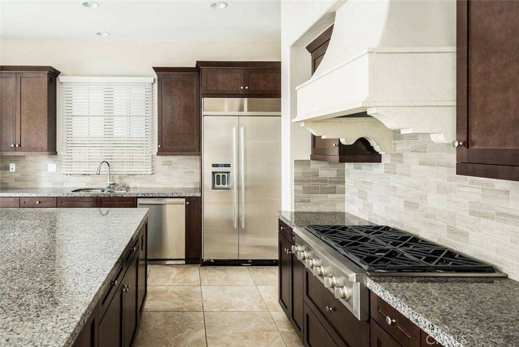 136 Long Fence Irvine, CA 92602 - Photo 15 of 26 a kitchen with granite countertop a sink stove and refrigerator