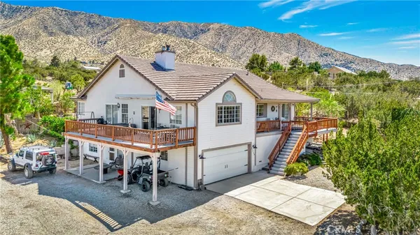 a palm tree sitting in front of a house with a yard