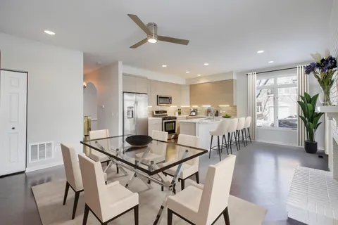 a kitchen with a dining table chairs and refrigerator