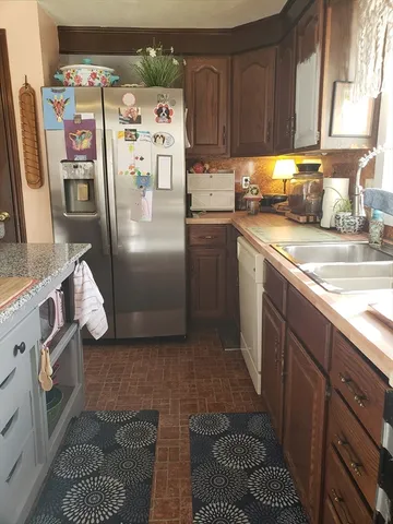 a kitchen with stainless steel appliances granite countertop a refrigerator a sink and a stove