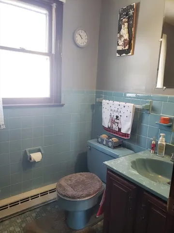 a bathroom with a toilet sink and mirror