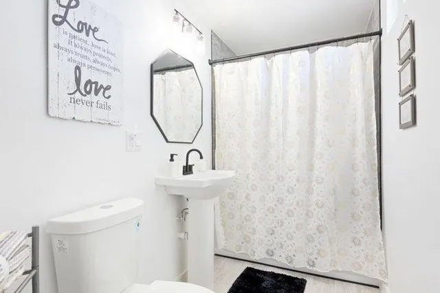 a bathroom with a sink a toilet and a mirror