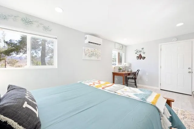 a bedroom with a bed and wooden floor