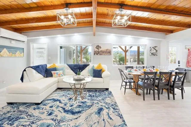 a living room with furniture a rug and white walls