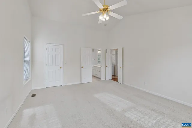 an empty room with fan and entrance