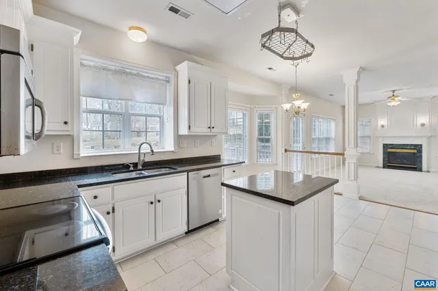 a kitchen with granite countertop kitchen island white cabinets and white appliances