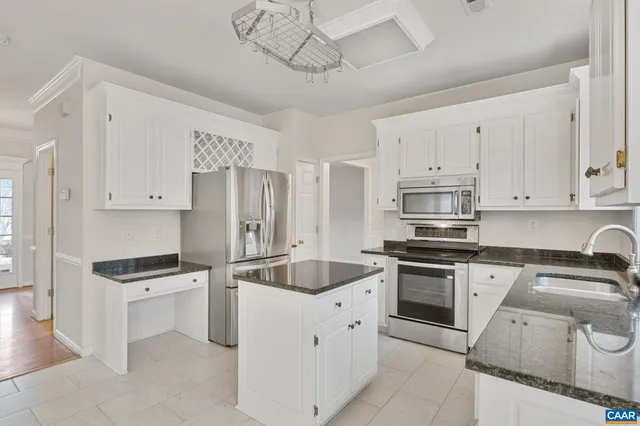 a kitchen with granite countertop white cabinets and stainless steel appliances