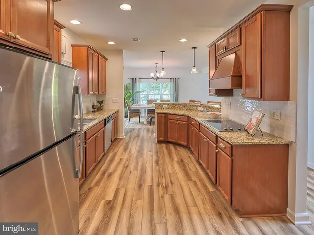 a spacious bedroom with a bed a dresser and windows