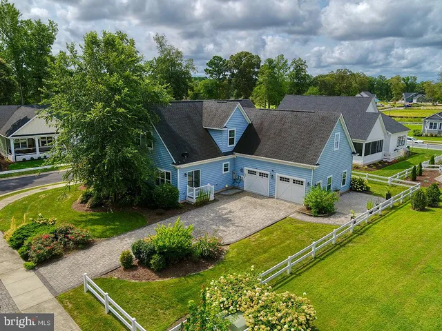 a front view of a house with a yard and potted plants