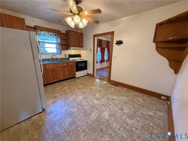 a large kitchen with a sink stainless steel appliances and chandelier