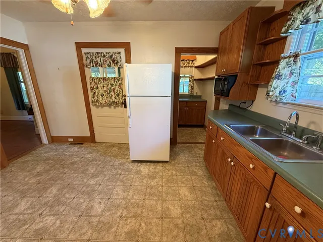 a kitchen with sink refrigerator and cabinets