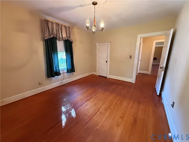 a view of a room with wooden floor staircase and a chandelier