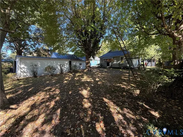 a front view of a house with a yard and tree