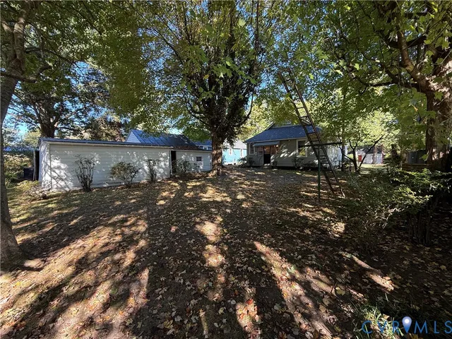 a front view of a house with a yard and tree