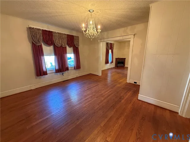 a view of a room with wooden floor chandelier and window