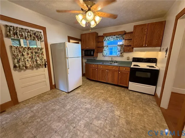 a kitchen with stainless steel appliances granite countertop a refrigerator a stove a sink dishwasher and wooden cabinets