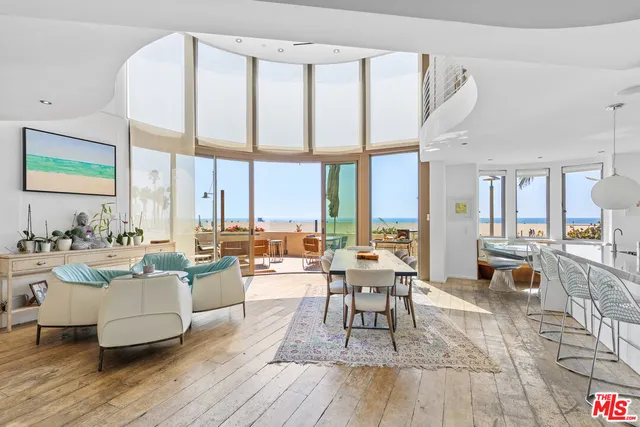 a living room with furniture wooden floor and a large window