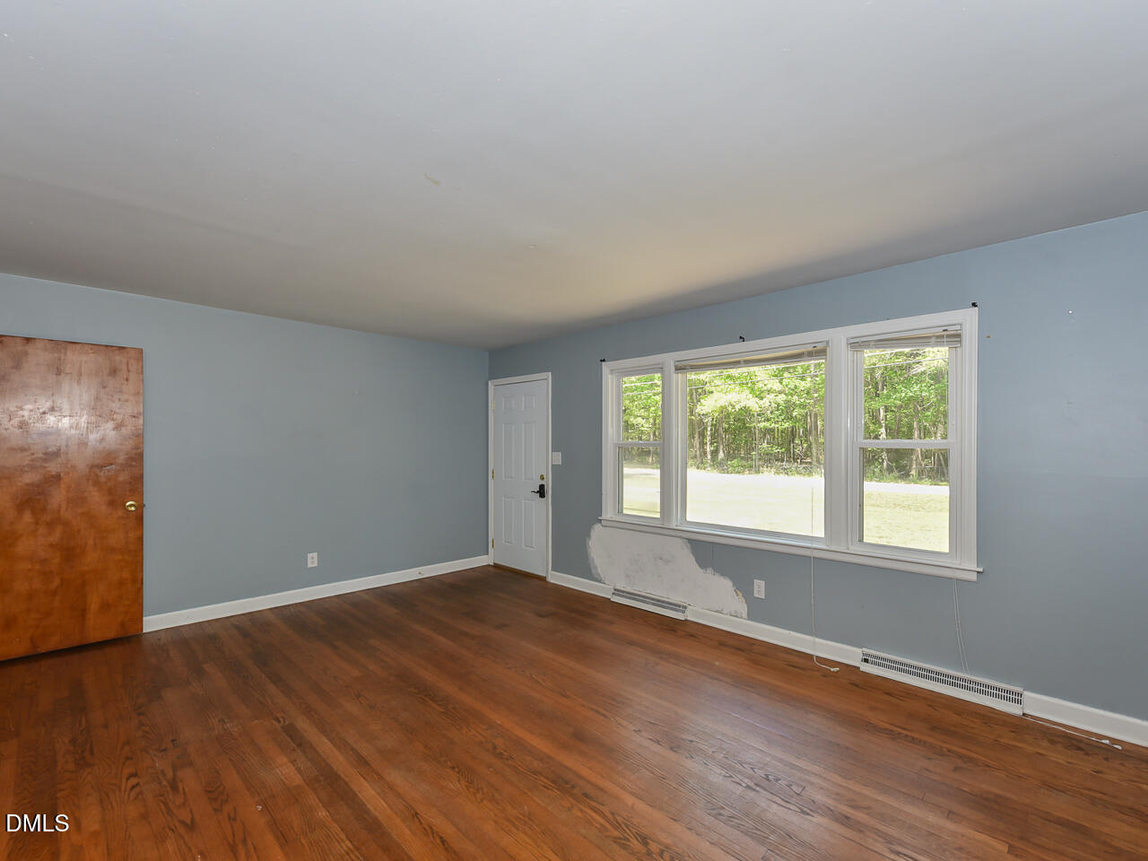 1703 St Patrick Drive Raleigh, NC 27603 - Photo 9 of 29 a view of an empty room with wooden floor and a window
