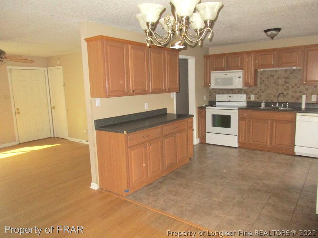 2181 Tingen Road Lillington, NC 27546 - Photo 27 of 36 a kitchen with granite countertop a stove a sink and dishwasher
