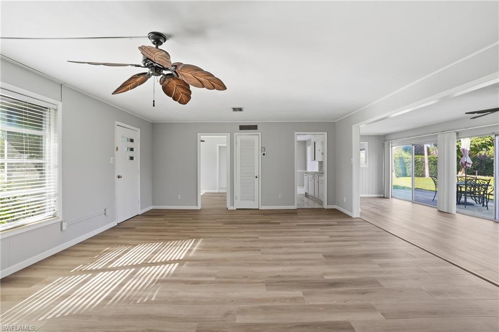 169 Viking Way Naples, FL 34110 - Photo 11 of 34 a view of an empty room with window and wooden floor