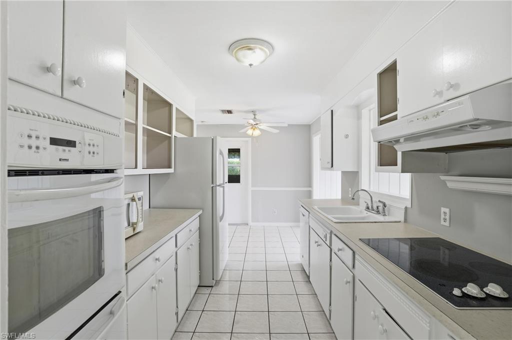 169 Viking Way Naples, FL 34110 - Photo 13 of 34 a large white kitchen with a sink and a stove top oven