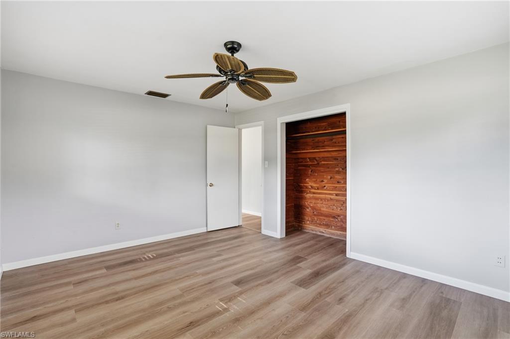 169 Viking Way Naples, FL 34110 - Photo 14 of 34 a view of an empty room with wooden floor and a window