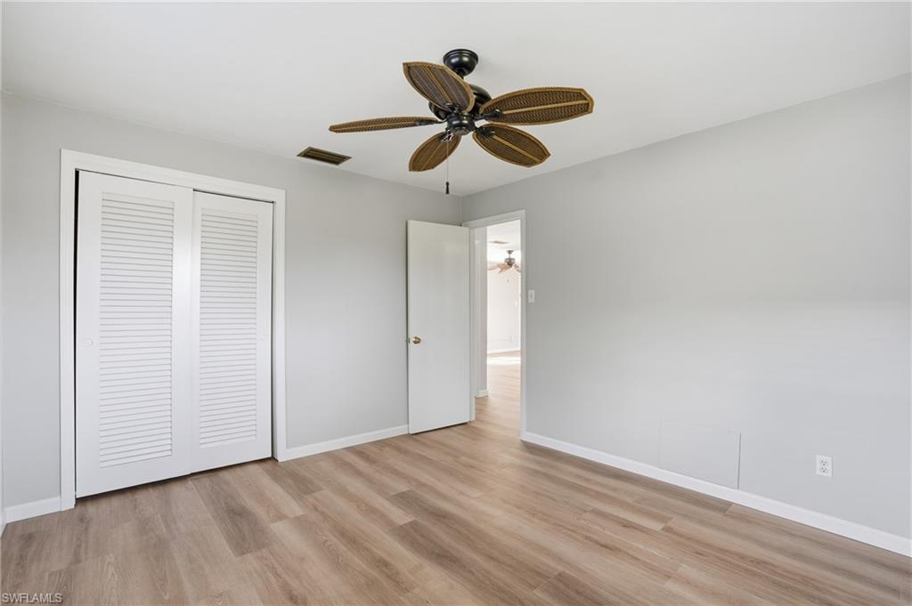 169 Viking Way Naples, FL 34110 - Photo 19 of 34 a view of an empty room with wooden floor and ceiling fan
