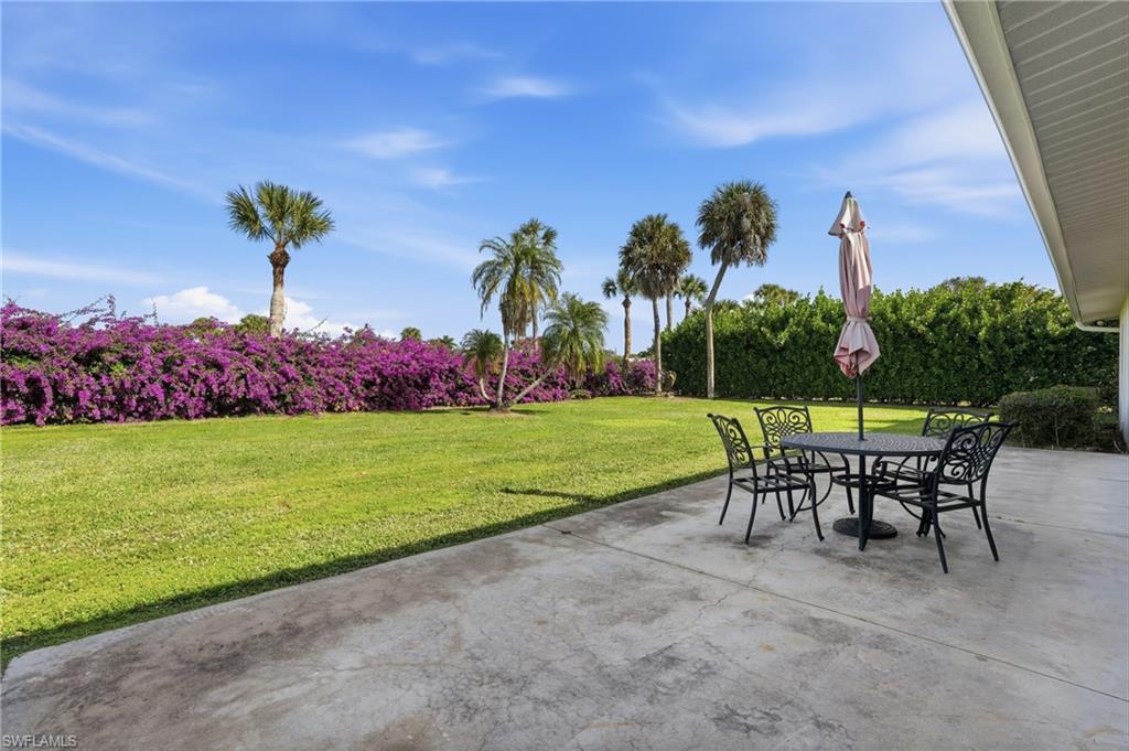 169 Viking Way Naples, FL 34110 - Photo 31 of 34 a view of a chairs and table in patio next to a yard