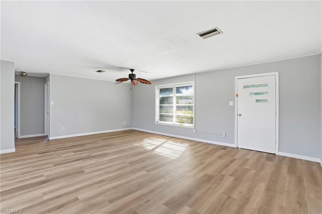 169 Viking Way Naples, FL 34110 - Photo 4 of 34 wooden floor in an empty room with a window