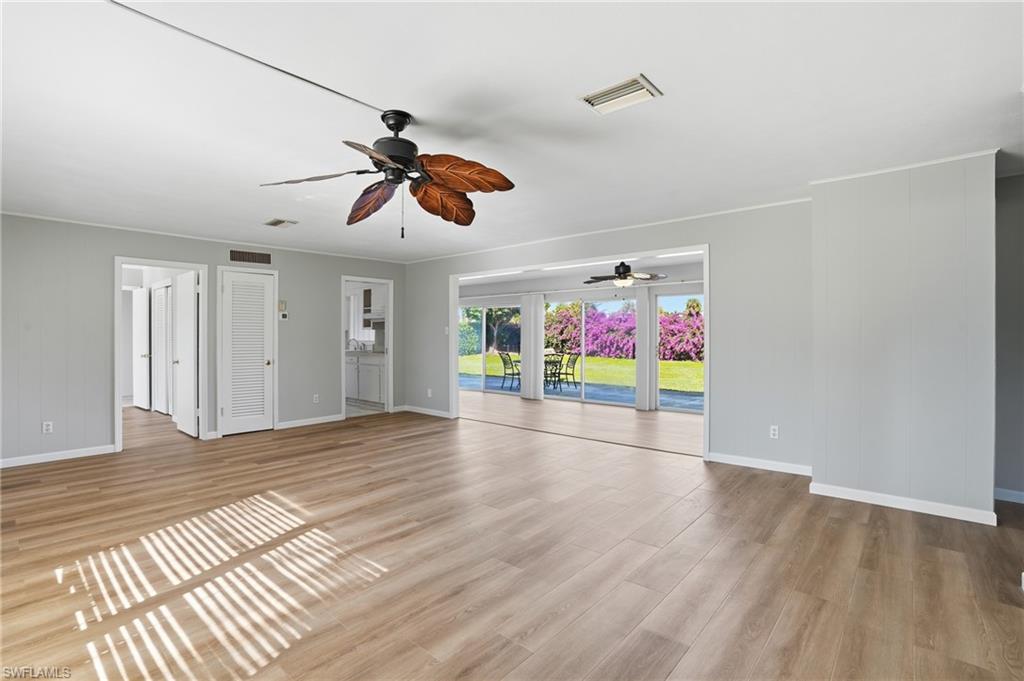 169 Viking Way Naples, FL 34110 - Photo 9 of 34 a view of an empty room with window and wooden floor