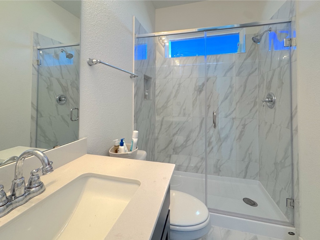 213 Camille Street Leander, TX 78641 - Photo 15 of 27 Bathroom with a textured wall, a marble finish shower, and vanity