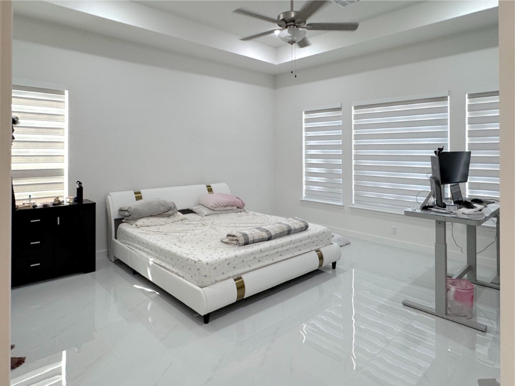 213 Camille Street Leander, TX 78641 - Photo 18 of 27 Bedroom featuring a tray ceiling, ceiling fan, and marble finish floors