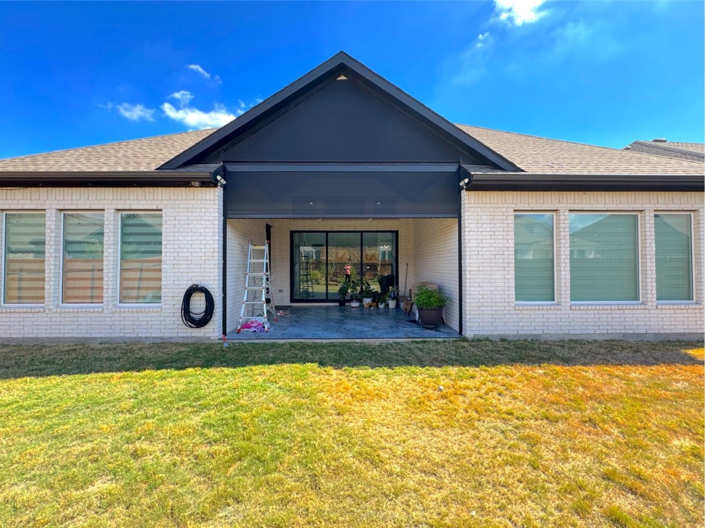 213 Camille Street Leander, TX 78641 - Photo 27 of 27 Rear view of property with brick siding, a patio area, a lawn, and roof with shingles